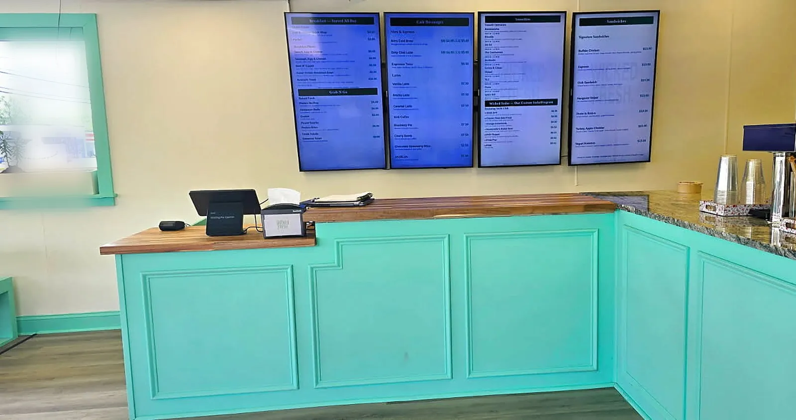Wicked Fresh Cafe counter with menu boards and turquoise cabinetry