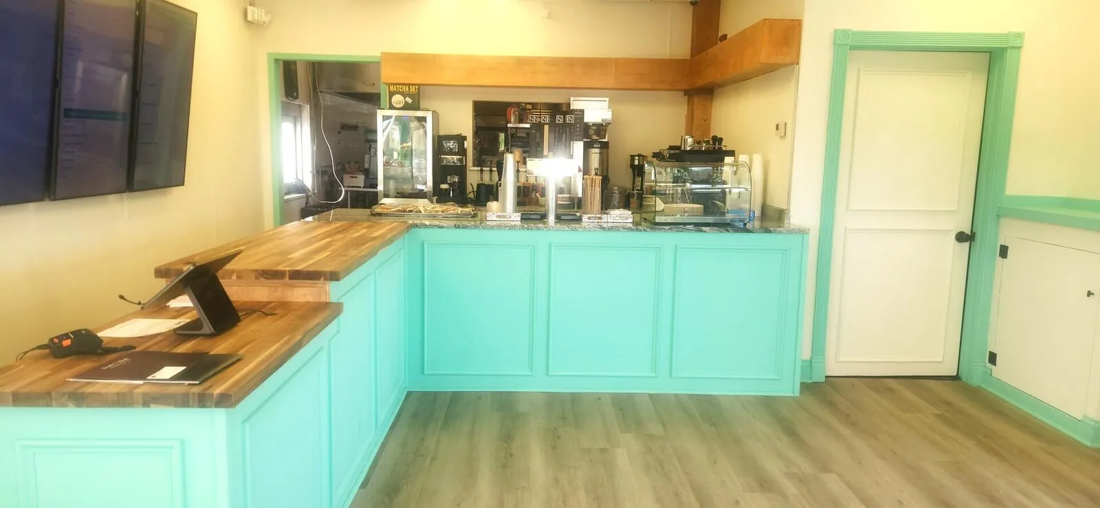 Coffee bar and prep area with turquoise cabinetry and butcher block counters