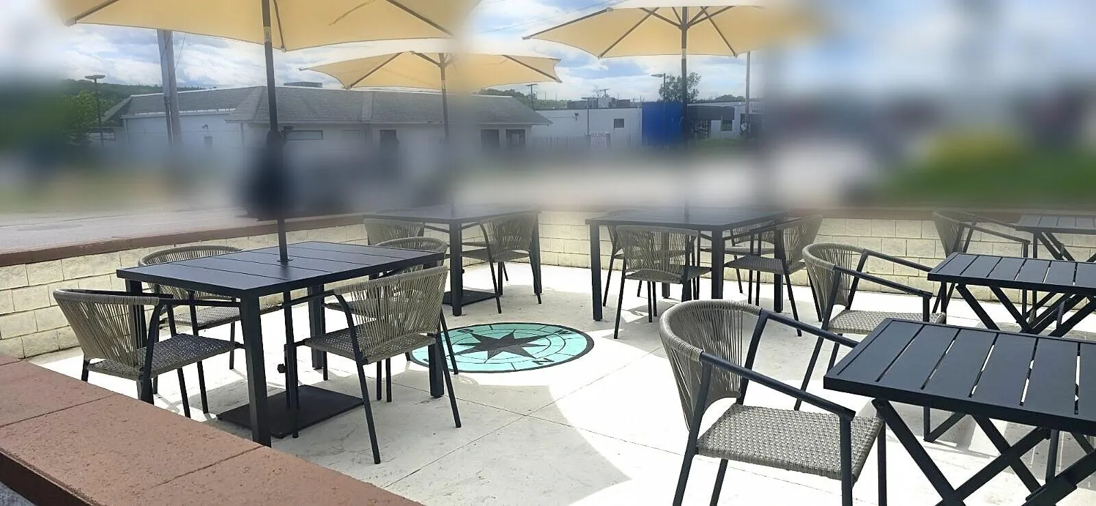 Outdoor patio with umbrella-covered tables on a sunny day